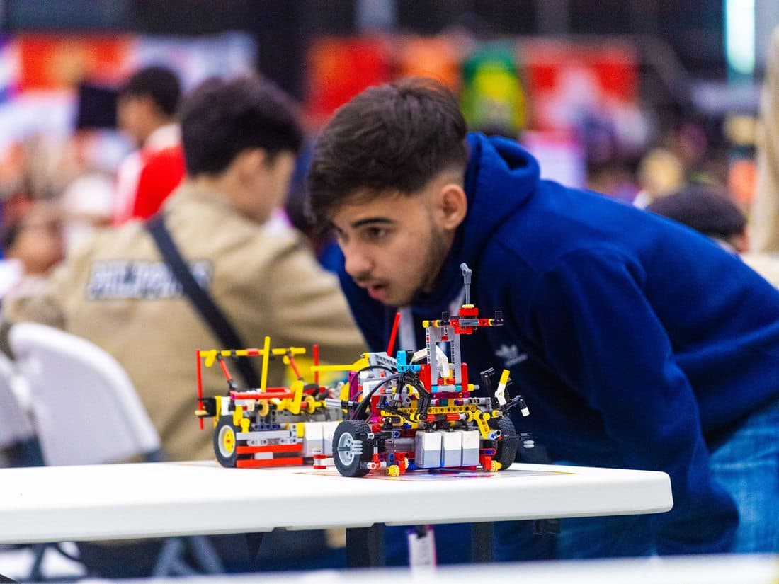 Estudante construindo seu robô durante a competição